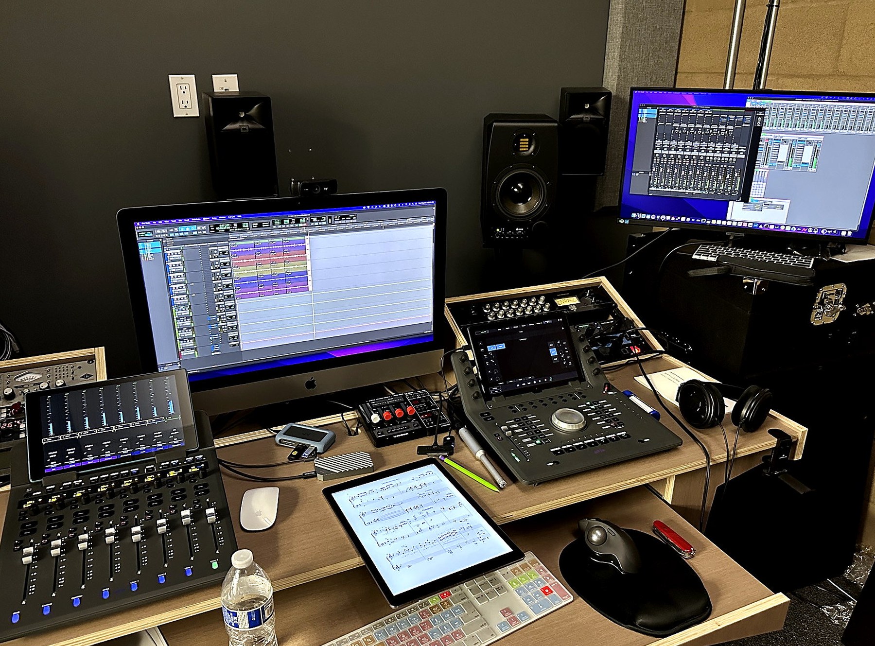 Mezo Records control room desk with monitors, mixing controls, and tablet
